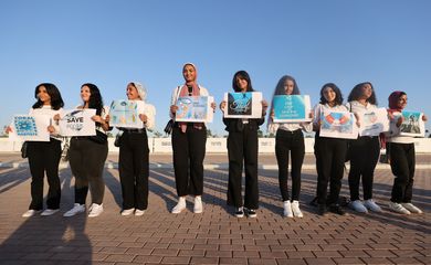 Ativistas seguram faixas enquanto se manifestam no Centro Internacional de Convenções de Sharm El Sheikh, durante a cúpula do clima COP27.