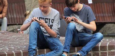 Jovens com celular jogando games