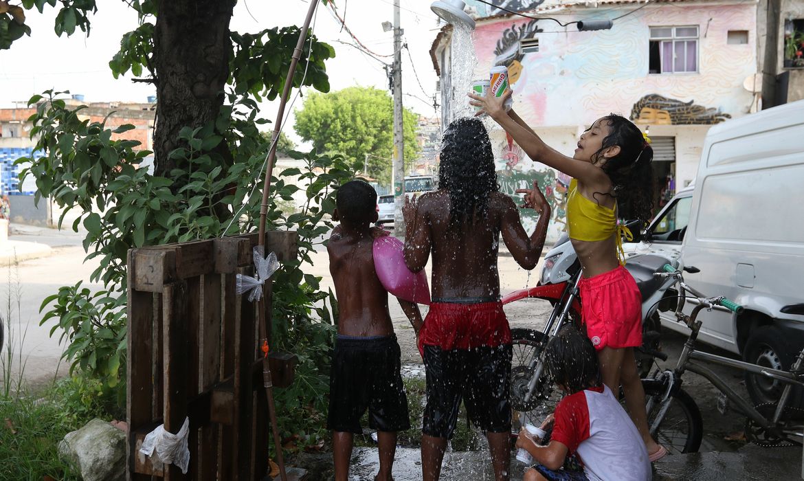 Rio de Janeiro (RJ), 16/11/2023 - Moradores do Complexo da Maré se refrescam com chuveiros e piscinas improvisadas nas ruas da comunidade. A sensação térmica na cidade do Rio de Janeiro voltou a superar os 50 graus Celsius (°C), com a onda de calor que atinge boa parte do Brasil. Foto: Tânia Rêgo/Agência Brasil