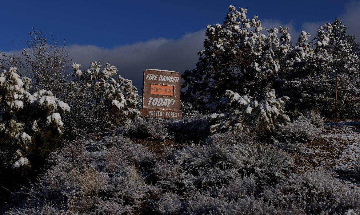 Neve sobre placa com alerta de incêncio em rodovia perto de Taylor, na Califórnia