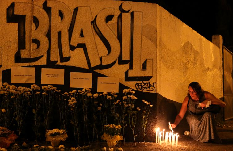 Uma mulher acende velas durante homenagem às vítimas do tiroteio na escola Raul Brasil em Suzano, São Paulo.