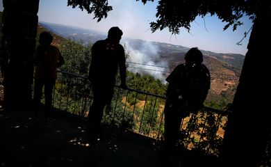 People watch a wildfire in Murca