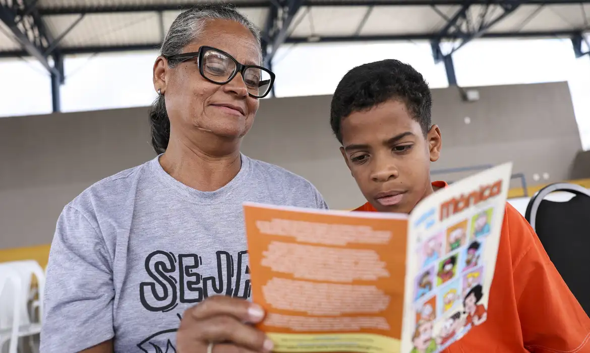 Brasília (DF), 26/03/2025 - Varlinda Leite e seu neto, Arthur Diogo, participam do lançamento de gibi da Turma da Mônica sobre intergeracionalidade em escola no Itapoã, região administrativa do Distrito Federal. Foto: Marcelo Camargo/Agência Brasil