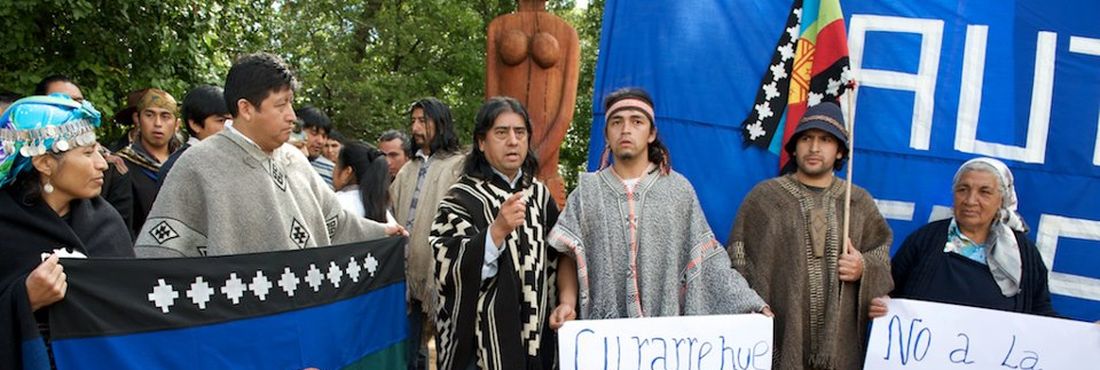 Líder mapuche Aucán Huilcamán, do Conselho de Todas as Terras, ao lado de manifestantes com cartazes