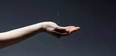 Mão feminina apara gotas de água