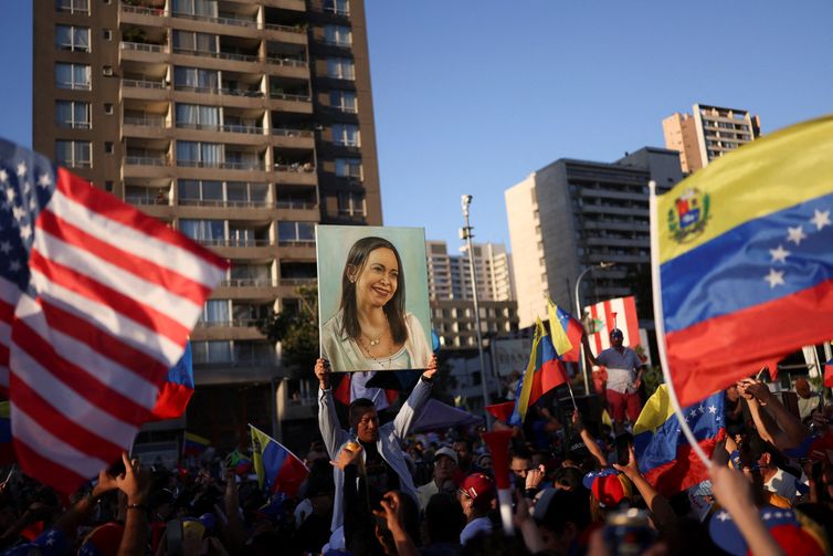Manifestante segura cartaz com a imagem da líder da oposição venezuelana María Corina Machado durante manifestação em Santiago
03/01/2026 REUTERS/Pablo Sanhueza