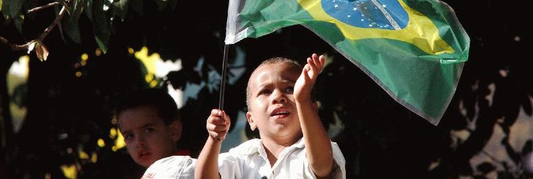 Criança brinca com a bandeira do Brasil