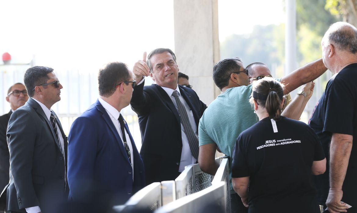 O presidente Jair Bolsonaro, cumprimenta populares  no Palácio da Alvorada