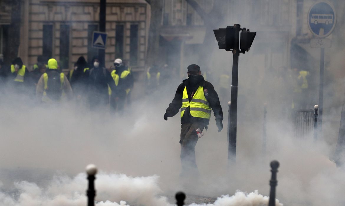 PAR16. Paris (France), 08/12/2018.- A Yellow Vests protester stands amid smoke during a demonstration in Paris, France, 08 December 2018. Police in Paris is preparing for another weekend of protests of the so-called 'gilets jaunes' (yellow vests