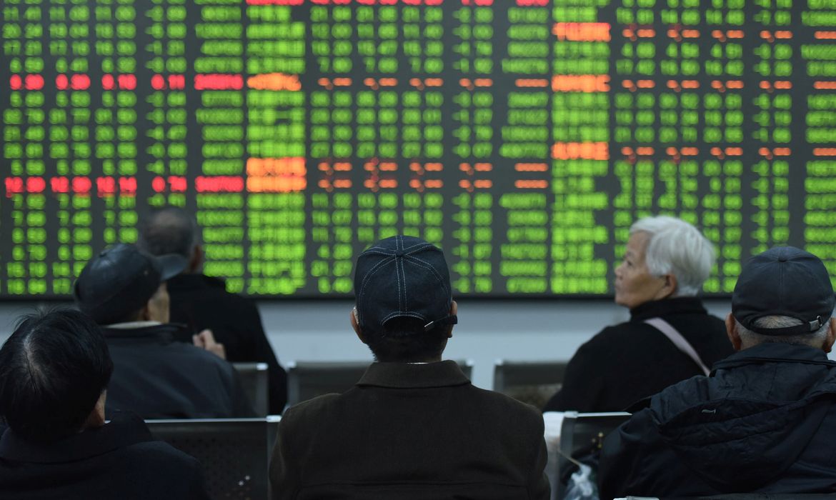 Os investidores estão diante de um quadro que mostra informações sobre ações em uma corretora no primeiro dia de negociação na China desde o Ano Novo Lunar, em Hangzhou, província de Zhejiang, China, em 3 de fevereiro de 2020. China Daily via REUTERS 