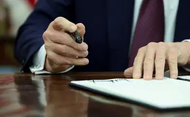 U.S. President Donald Trump signs an executive order in the Oval Office of the White House, in Washington, U.S., January 23, 2025.   Reuters/Kevin Lamarque/Proibida reprodução
