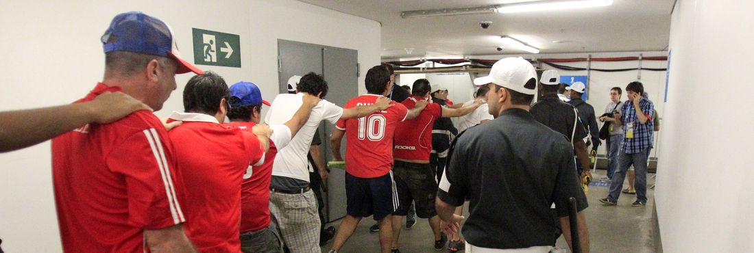 Torcedores chilenos são acompanhados por seguranças após tentativa de invasão ao centro de imprensa no Maracanã antes do início da partida contra a Espanha pelo grupo B