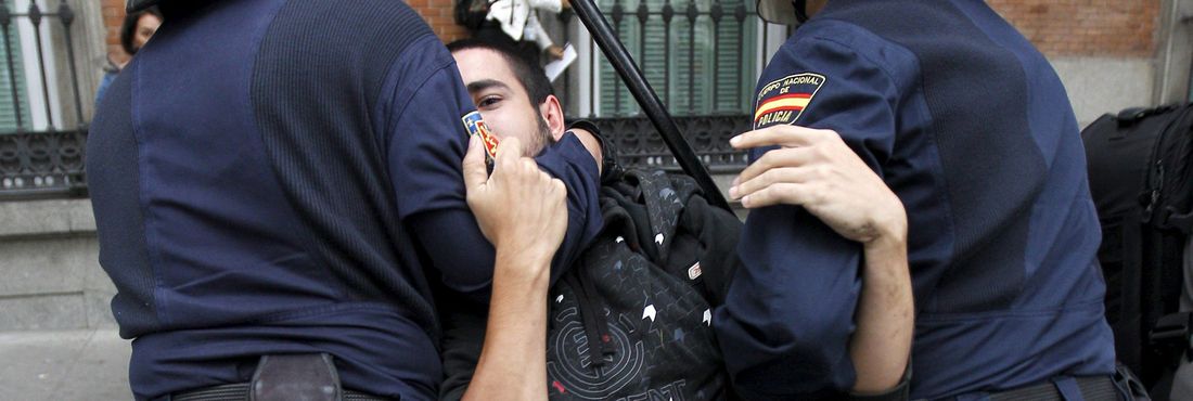 Manifestante detido por policiais durante protesto na Espanha
