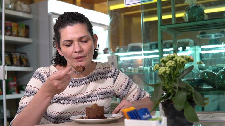 TV Brasil Claudete saboreia o bolo sem glúten.