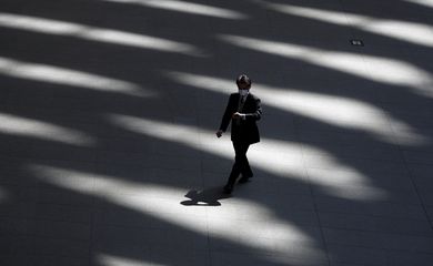 A man wearing a protective face mask, following an outbreak of the coronavirus disease, walks past inside an almost empty convention complex in Tokyo, Japan