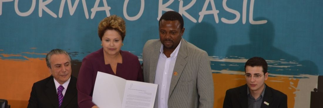 Brasília - Presidenta Dilma Rousseff, ao lado do ator Érico Brás, sanciona o Estatuto da Juventude. O estatuto foi aprovado pelo Congresso Nacional no dia nove de julho, após mais de nove anos de tramitação