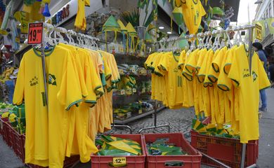 No Saara, comércio popular no centro do Rio, decorado com bandeiras do Brasil, para onde se olha, as lojas exibem as cores verde e amarelo da camisa da seleção 
