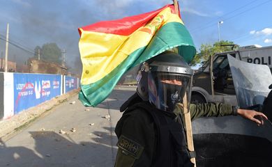 A riot police officer with a Bolivian flag is seen in Sacaba, on the outskirts of Cochabamba, Bolivia, November 15, 2019. REUTERS/Danilo Balderrama