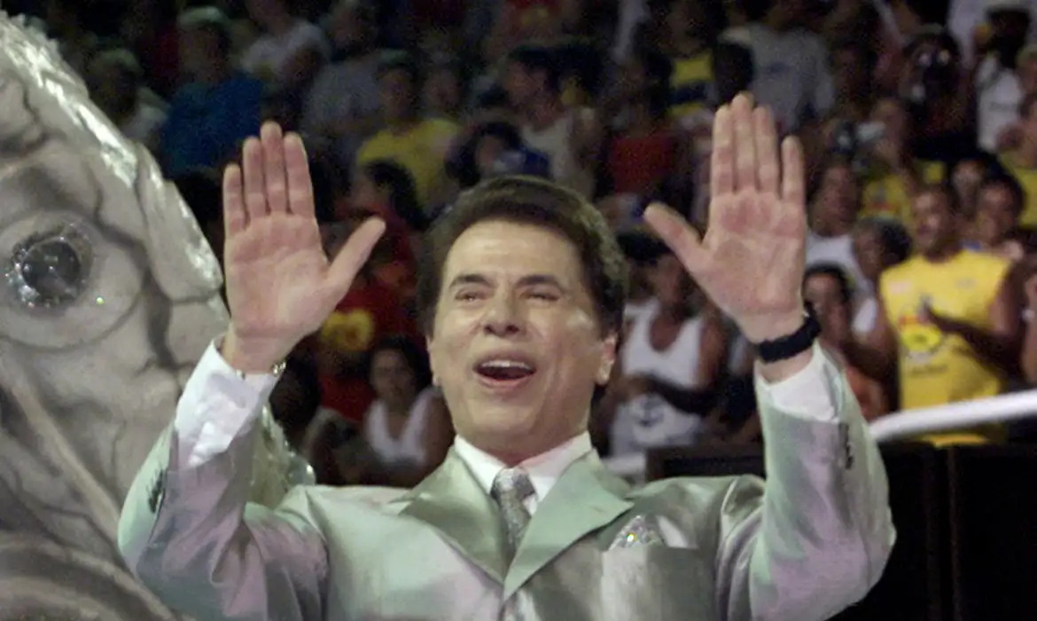 FILE PHOTO: Brazil's most famous TV personality and host of various game shows Silvio Santos waves to the crowd from atop his float for the 'Tradicao' samba school during a late-evening parade at the Sambadrome stadium in Rio de Janeiro February 25, 2001. Reuters/Gregg Newton/Proibida reprodução