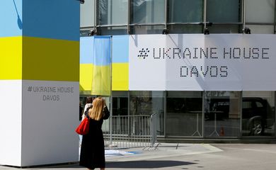 A woman stands in front of the Ukraine House Davos in Davos