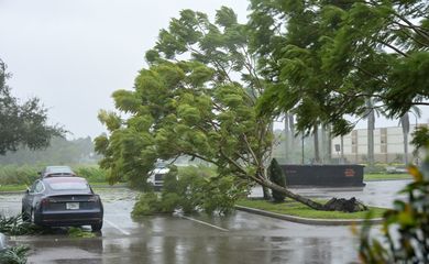 Os primeiros ventos do furacão Ian derrubam árvores em estacionamento de hotel em Sarasota, na Flórida. REUTERS/Steve Nesius