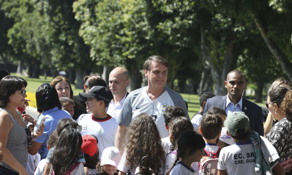 O presidente Jair Bolsonaro vem até a entrada do Palácio da Alvorada, e conversa com crianças e posa para fotos.