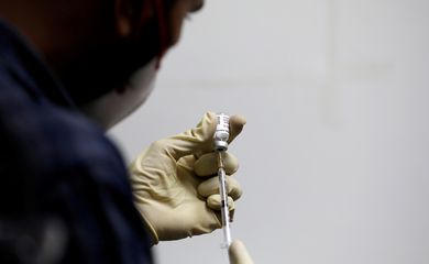 FILE PHOTO: A medic fills a syringe with COVAXIN, an Indian government-backed experimental COVID-19 vaccine, before administering it to a health worker during its trials, in Ahmedabad