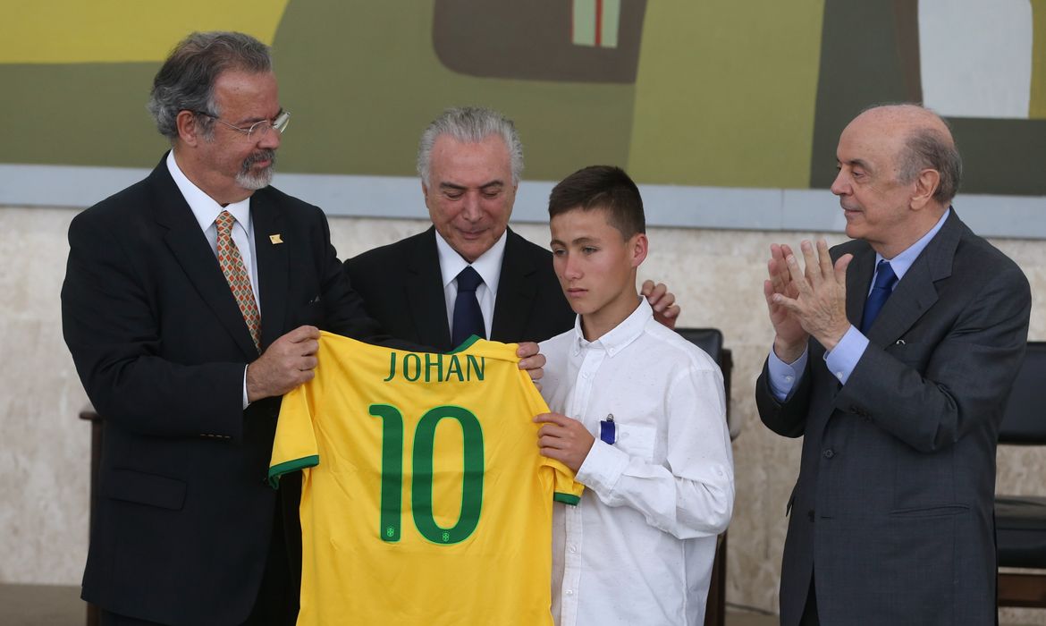 Brasília - Raul Jungmann e o presidente Temer entregam uma camisa da Seleção Brasileira personalizada a Johan Alexis Ramirez Castro, junto a José Serra (Valter Campanato/Agência Brasil)