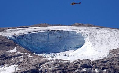 Helicóptero participa de operação de busca e resgate sobre o local de um colapso de partes de uma geleira nos Alpes italianos, no cume da Marmolada,