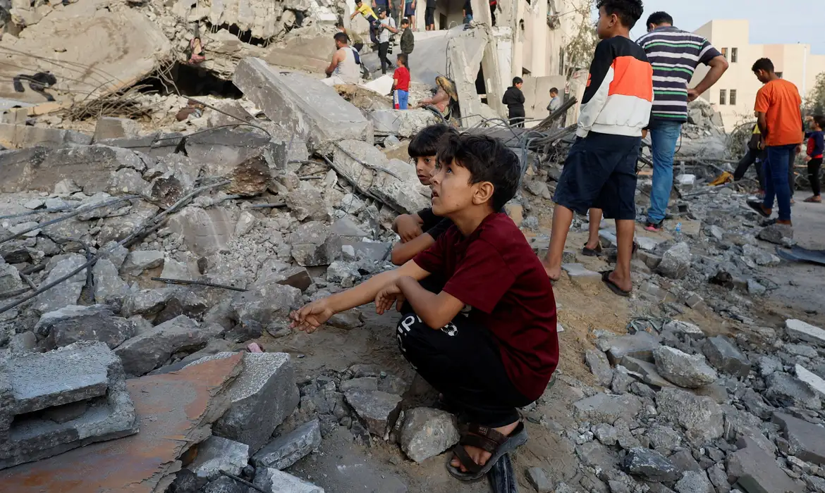 Palestinos observam destroços de prédio destruído em ataque israelense em Khan Younis
17/10/2023
REUTERS/Mohammed Salem