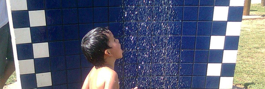 Criança bebe água de ducha no verão