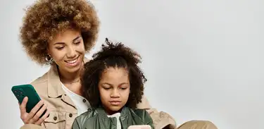 Mãe e criança usam celular