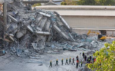 Rescue personnel gather near a building that collapsed after a strong earthquake struck central Myanmar on Friday, earthquake monitoring services said, which affected Bangkok as well with people pouring out of buildings in the Thai capital in panic after the tremors, in Bangkok, Thailand, March 28, 2025. REUTERS/Athit Perawongmetha
