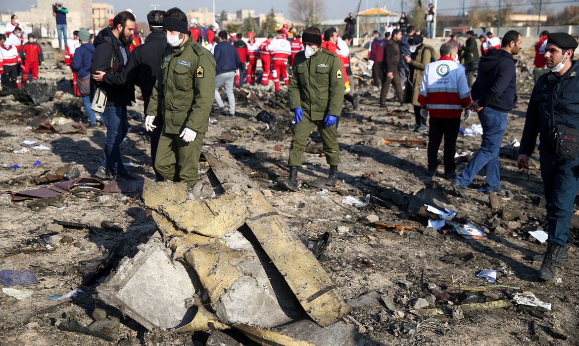
Oficiais de segurança e trabalhadores do Crescente Vermelho são vistos no local onde o avião da Ukraine International Airlines caiu após a decolagem do aeroporto Imam Khomeini, no Irã, nos arredores de Teerã, no Irã, em 8 de janeiro de 2020.