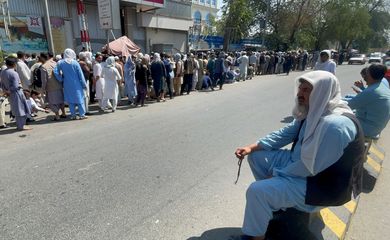 Afghans line up outside a bank to take out their money after Taliban takeover in Kabul