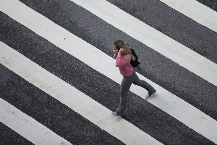 REUTERS/Rahel Patrasso/Direitos reservados Mulher com máscara de proteção em avenida de São Paulo