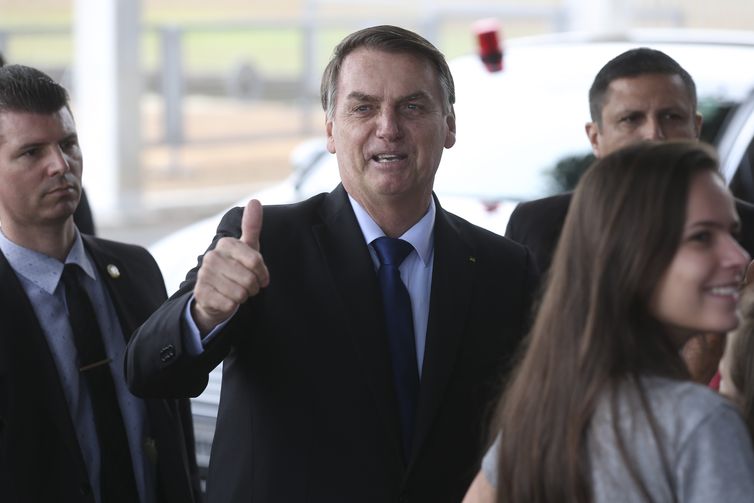 O presidente Jair Bolsonaro recebe cumprimentos e tira fotos na entrada do Palácio da Alvorada.