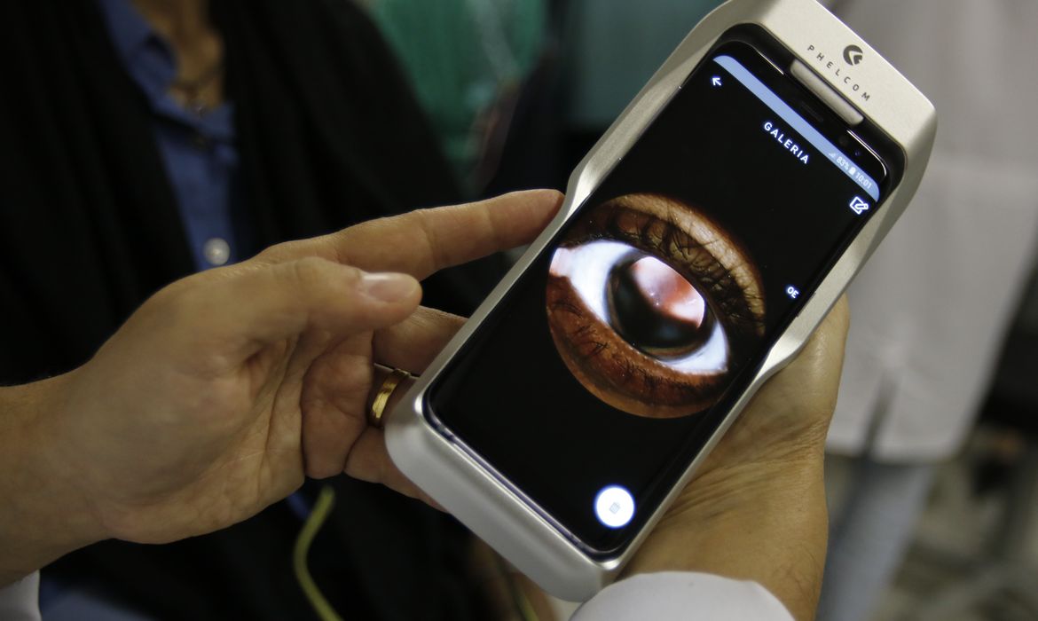  O Dr. Flávio Medina realiza exame de fundo de olho com um retinógrafo portátil,
