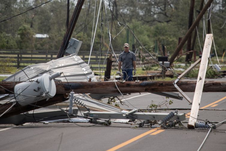 Um homem passa por cabos elétricos caídos para chegar à sua residência após o furacão Laura em Sulphur, Louisiana, EUA, 27 de agosto de 2020. REUTERS / Adrees Latif