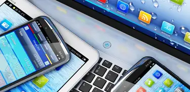 Tablets e smartphones em cima de um teclado de computador