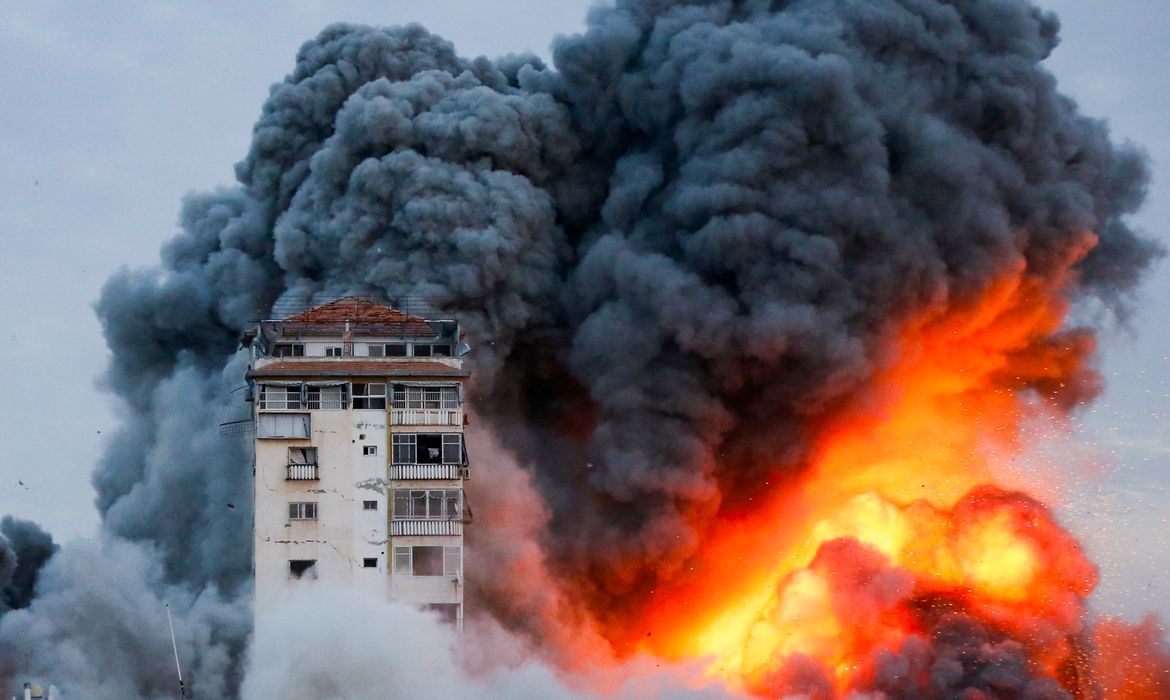 Fogo e fumaça saem de prédio após ataque de forças de Israel em Gaza. REUTERS/Ashraf Amra