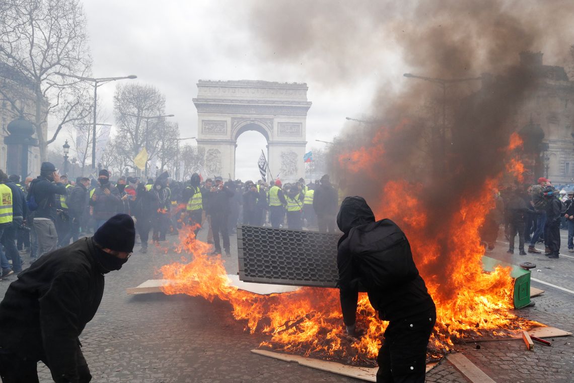 Os manifestantes reagem ao lado de uma barricada em chamas, durante uma demonstração do movimento &quot;coletes amarelos&quot; em Paris, França, em 16 de março de 2019. REUTERS / Philippe Wojazer