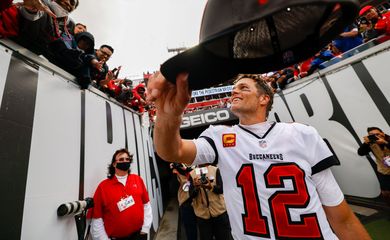 Tom Brady entrega seu boné para um torcedor depois de partida da NFL