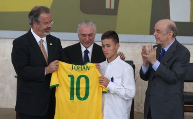 Brasília - Raul Jungmann e o presidente Temer entregam uma camisa da Seleção Brasileira personalizada a Johan Alexis Ramirez Castro, junto a José Serra (Valter Campanato/Agência Brasil)
