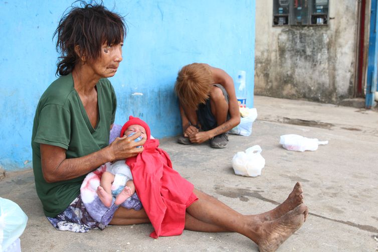 Boa Vista (RR), 13-02-2023, Cláudia Yanomami alimenta o neto recém nascido na calçada da rua Estrela D'Alva. Ela faz parte de um grupo de cerca de 20 yanomami sem teto que estão acampados às margens da BR-174.