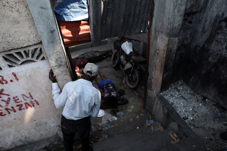 Uma pessoa olha para os corpos de pessoas que foram encontradas mortas no subúrbio de Petion-Ville, enquanto gangues rivais disputam o controle do território enquanto o estado permanece em grande parte ausente, em Porto Príncipe, Haiti 1º de abril de 2024. REUTERS/Ralph Tedy Erol