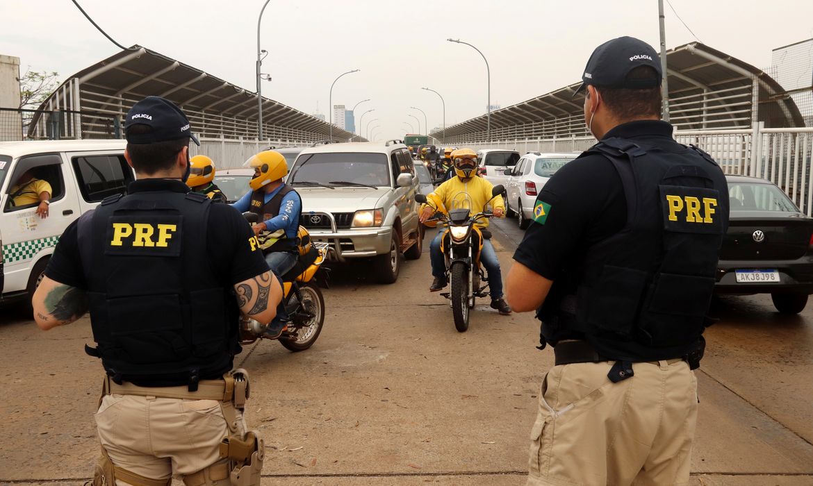 Policiais Rodoviários Federais controlam o fluxo de veículos na Ponte da Amizade Internacional que liga seu país ao Paraguai, que ficou fechada por meses devido ao surto da doença coronavírus (COVID-19) em Foz do Iguaçu
