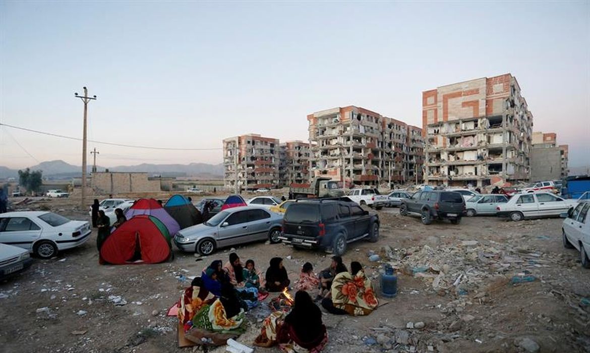 Vítimas iranianas do terremoto se reúnem em ambiente aberto na cidade de Pole-Zahab, em Kermanshah. De acordo com as autoridades, o abalo foi de magnitude 7.2 na escala Richter