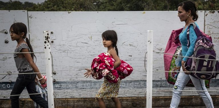 Refugiados e migrantes venezuelanos cruzam a ponte Simon Bolívar, um dos sete pontos de entrada legal ao longo da fronteira entre Venezuela e Colômbia