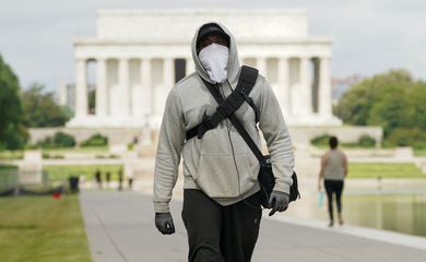 A man wears face mask and gloves while walking the National Mall during the coronavirus disease (COVID-19) pandemic in Washington